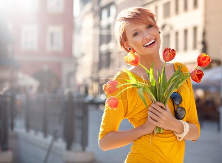 Smiling woman with bunch of flowers
