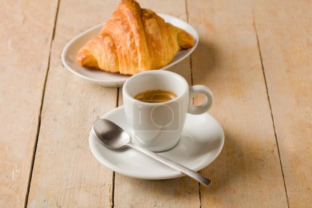 Coffee and croissants on wooden table