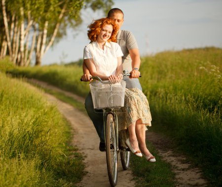 Happy young couple riding on a bicycle