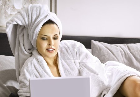 Lady with laptop on bed