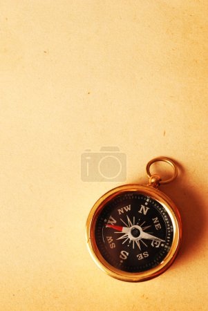 Antique brass compass over old backgroun
