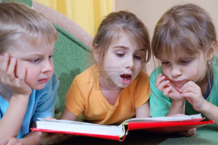 two little kids read a book 