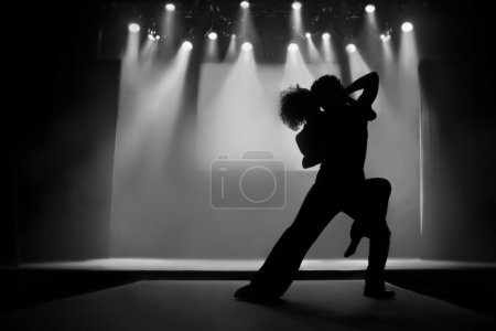 Couple in silhouette dancing on a stage