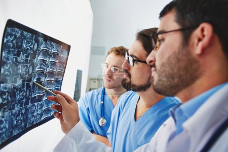 Young male doctors looking at x-ray
