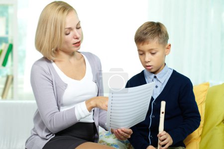 Boy learning notes with tutor