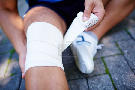 Man bandaging leg