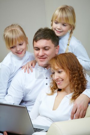 Family watching film by laptop
