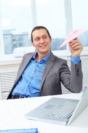 Businessman playing with paper plane