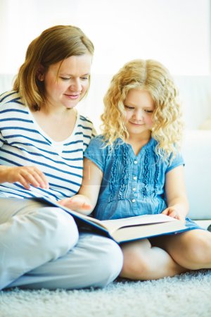 Girl and her mother reading a book