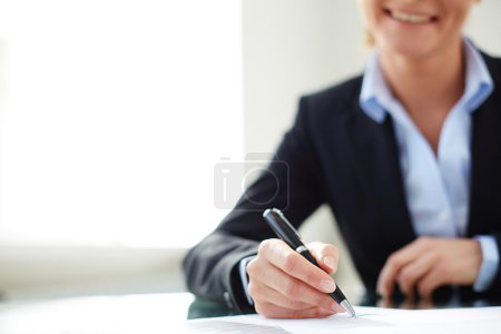 Female hand signing document