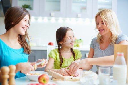Girls helping mother to cook pastry