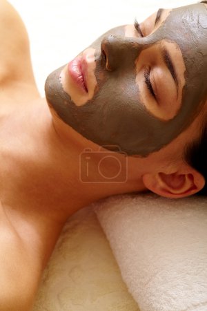Girl with clay mask on face