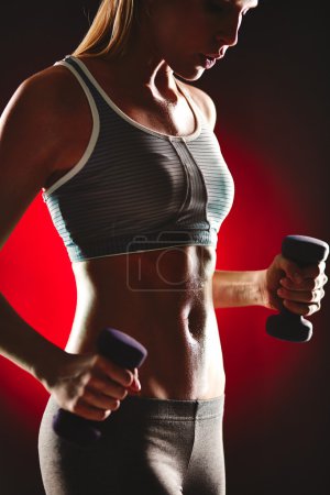 Female doing exercise with dumbbells
