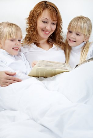 Mother reading to her daughters