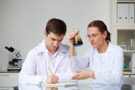Scientists making analysis of liquid