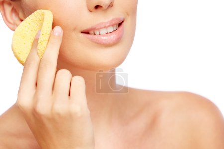Woman cleaning face with sponge