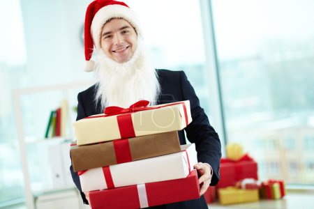 Businessman holding present in red giftboxes