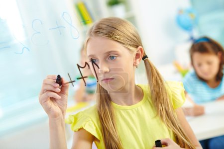 Girl doing sums on transparent board