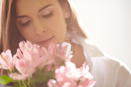 Lady smelling flowers