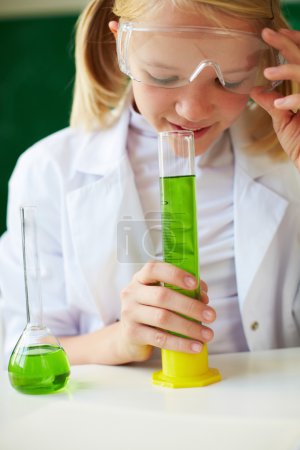 Schoolgirl smelling chemical tube