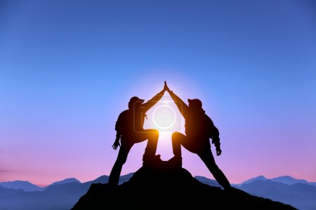 The Silhouette of two man with success gesture standing on the top of mountain