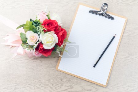 Wooden Clipboard attach planning paper with pencil beside rose b