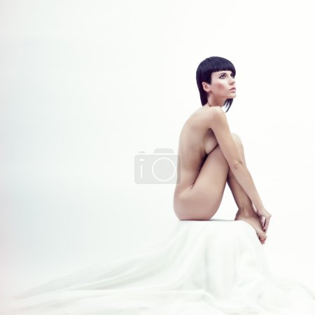 Nude beautiful sitting woman in white room