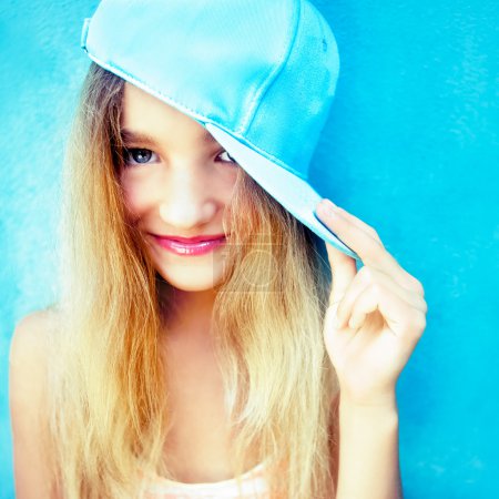 Portrait of cute teen girl in blue wall
