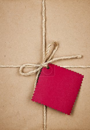 Gift with red tag in brown paper