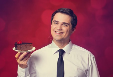 Man holds cake, on red background