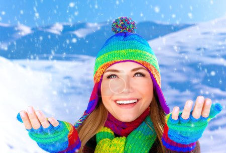 Cheerful female catching snowflakes