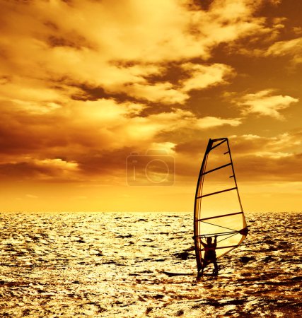 Silhouette windsurfer over sunset