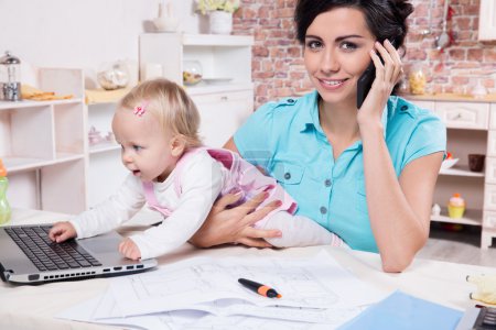 Business woman with laptop and her baby girl