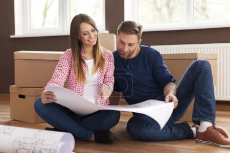 Couple checking blueprints of new home