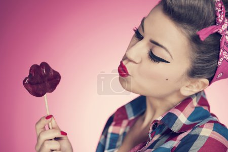 Pin-up girl with lips shaped lollipop