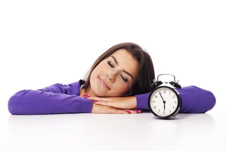 Sleeping beautiful woman with alarm clock