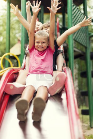 Happy kids slide on playground