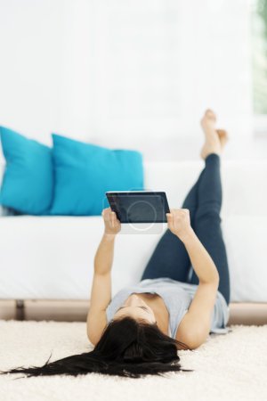 Young woman using tablet on the floor