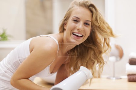 Blonde woman drying hair