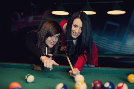 Two girls playing pool game