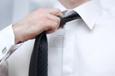 Businessman adjusting tie