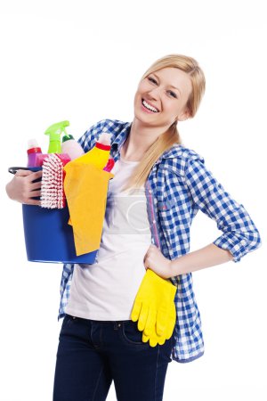 Happy housewife holding cleaning equipment
