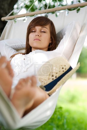 Young woman sleeping on hammock