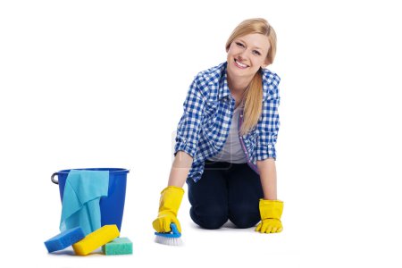Young and smiling woman cleaning a floor