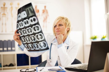 Female doctor studying x-ray image
