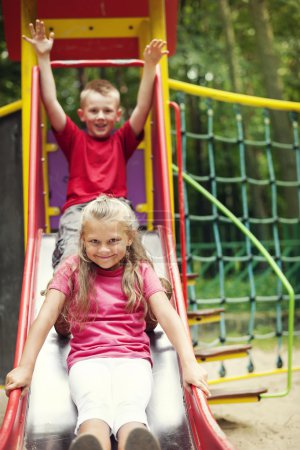 Two kids having fun on slide