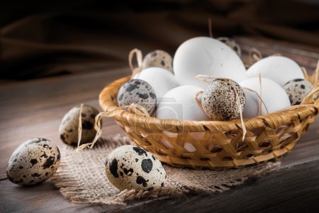 Quail and chicken eggs in a basket