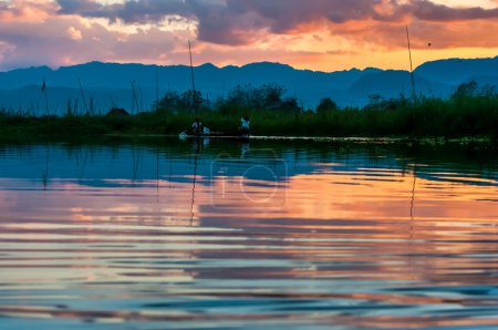 Fishermen and their reflection in the water on the Inle Lake, Myanmar