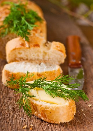 Fresh bread and butter on a wooden board