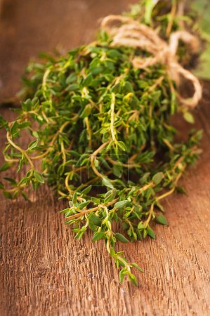 Thyme bunch with a rough rope on a wooden board